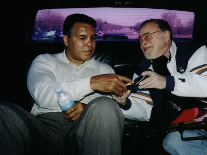 Muhammad Ali rides with Jerry Izenberg in the back of a car.